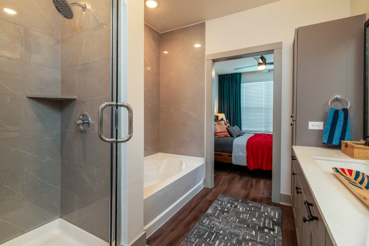 On-suite bathroom with a large tub and glass shower and ample counterspace inside a home at The Briarly