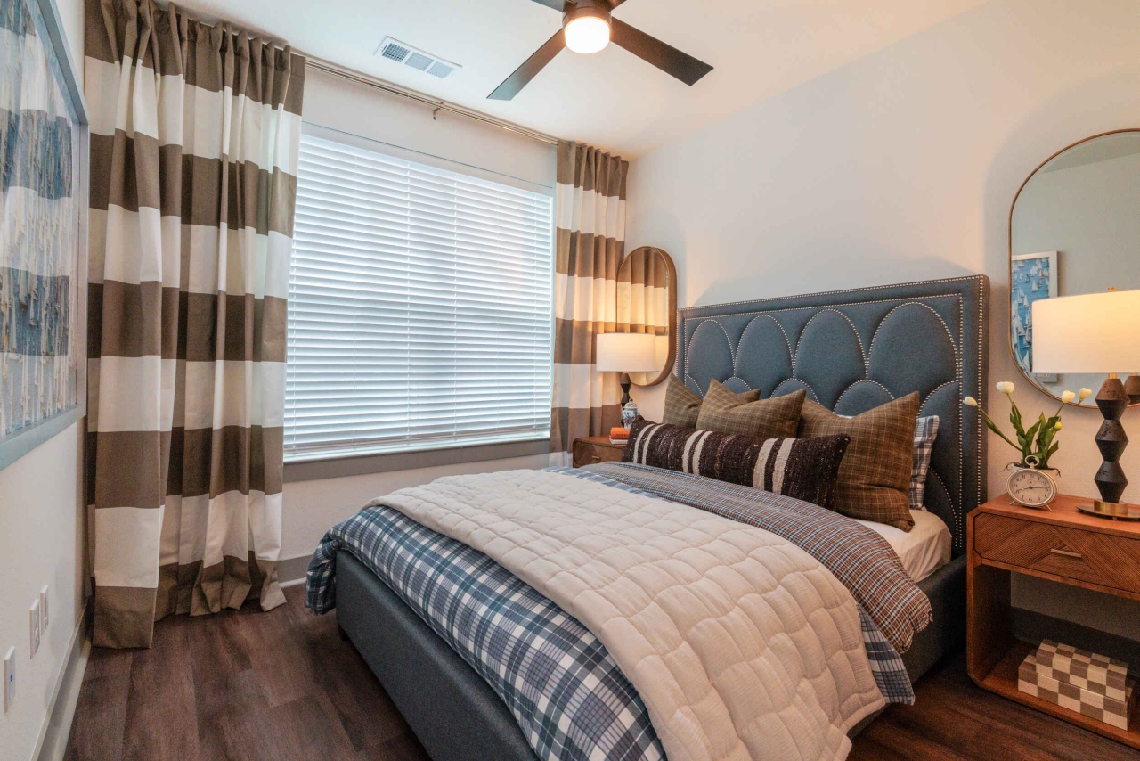 Large windows and ceiling fans inside apartment bedrooms at The Briarly